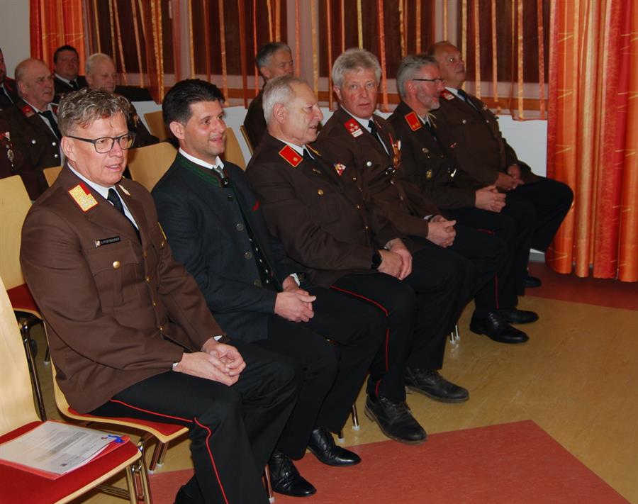 Eine Gruppe von Männern in Militäruniformen sitzt auf Stühlen